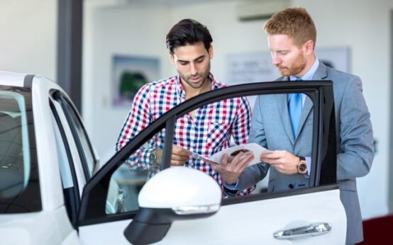 A Potential Buyer Reviewing Car Finance Options at a Dealership