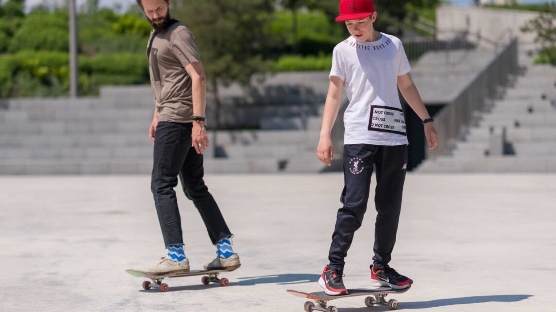 Two skateboarders are wearing their new men’s skate shirts.